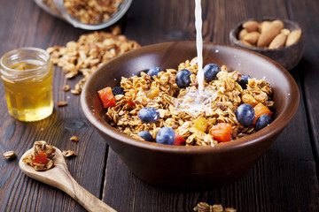 Healthy breakfast. Fresh granola, muesli with berries, honey and milk 