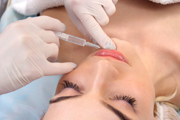 Beautiful woman gets an injection in her lips.