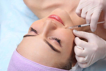 Beautiful woman gets an injection in her face.