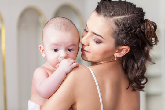 Happy family laughing faces, mother holding adorable child baby boy, smiling and hugging