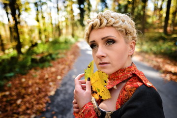 Beautiful elegant blonde woman in autumn forest