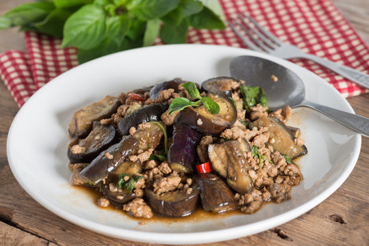 Stir fried eggplant with minced pork and basil in white plate.