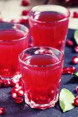 Fresh pomegranate juice on a black background, selective focus