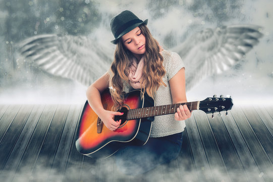 Singing Angel. Portrait of a beautiful girl with a guitar, behind which the wings.