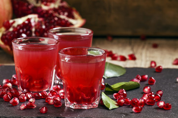 Fresh pomegranate juice on a black background, selective focus