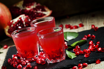 Fresh pomegranate juice on a black background, selective focus