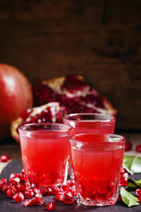 Fresh pomegranate juice on a black background, selective focus