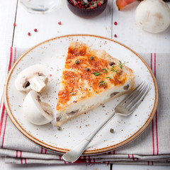 Mushroom, champignon pie, quiche slice on a ceramic plate