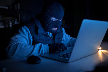 Computer hacker stealing data from a laptop