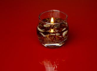 Ornamental glass candle on isolated red