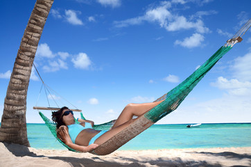Carefree young woman relaxing on tropical beach - obrazy, fototapety, plakaty