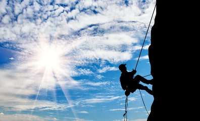 Fototapeta na wymiar Silhouette climber climbing a mountain