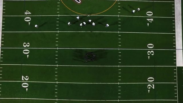 Birds eye view of a football team in a huddle before a play, view from above
