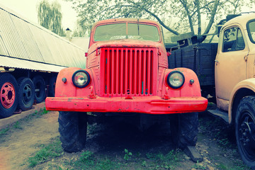 Old rusty red farm trucks fading in time frontview.