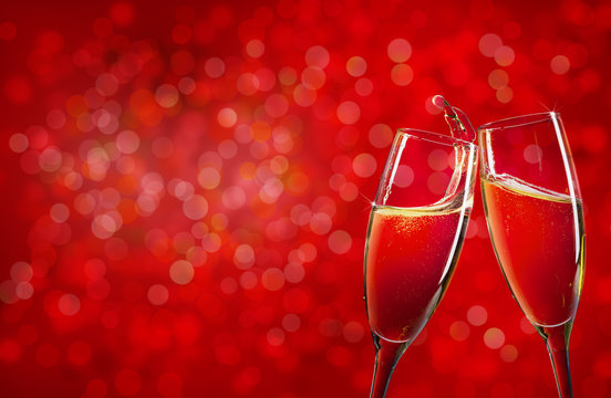 Two Champagne Glasses Over Red Christmas Background