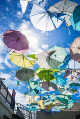 Street decorated with pastel colored umbrellas in sunny day