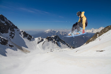Naklejka na ściany i meble Flying snowboarder on mountains