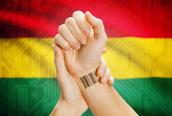 Barcode ID number on wrist and national flag on background - Bolivia