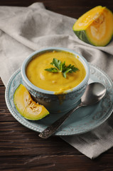 Pumpkin soup with parsley on vintage table