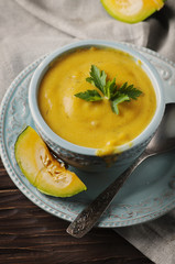 Pumpkin soup with parsley on vintage table
