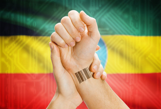Barcode ID number on wrist and national flag on background - Ethiopia