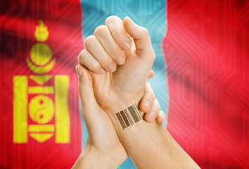 Barcode ID number on wrist and national flag on background - Mongolia