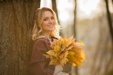 Blond woman with bouquet from maple leaves