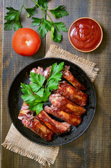 Grilled pork ribs on wooden table, top view