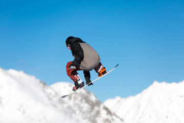 Fototapeta na wymiar Snowboarder jumping in snow park