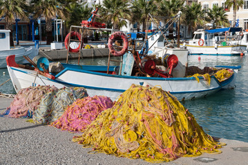 Traditional wooden boats and fishing nets in the harbor of Kos island, Greece