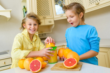 Children with citrus. Boys squeezing fresh orange juice