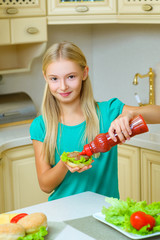 smiling girl make homemade hamburger or sandwiche at kitchen