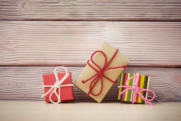 Fototapeta na wymiar Gift boxes over light wooden background