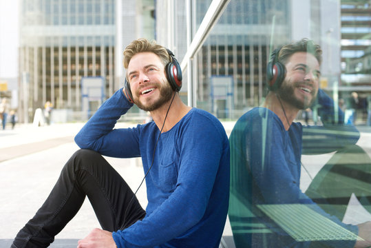 Cool man smiling outside with headphones