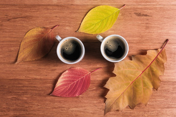 Two cups of coffee with autumn leaves