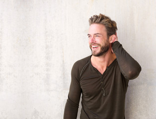 Handsome man with beard laughing with hand in hair