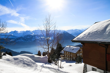 Panoramic skyline view of snow-capped chalets and mountains lake