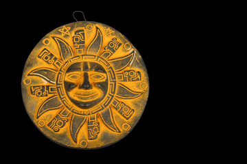 Mexican yellow ceramic sun souvenir isolated on black