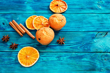 
orange muffins with chocolate , cinnamon , cocoa and spices on a wooden background