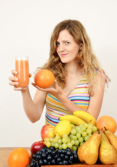 Obraz premium Blonde young woman making fresh juice out of fruits