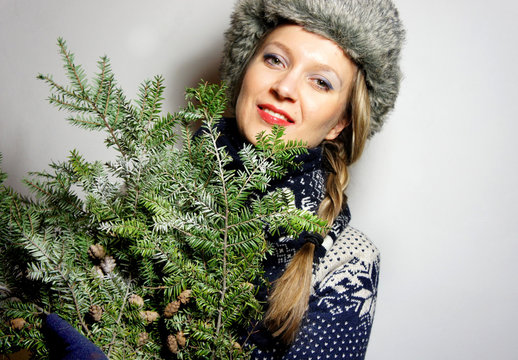 Beautiful young woman with Christmas tree