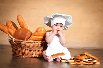 Little cook with a bagel in her hands.