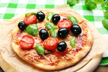 Tasty pizza with vegetables and basil on table close up