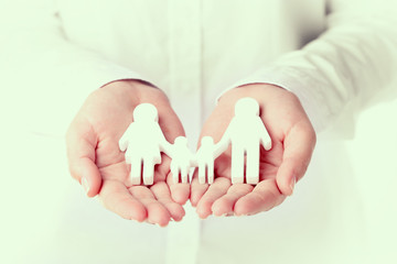 Female hands holding toy family, closeup