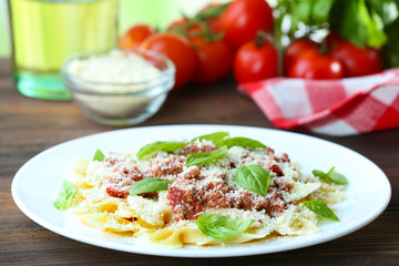 Pasta bolognese in white plate on wooden table, closeup