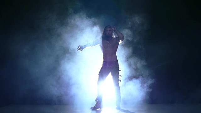 Full length silhouette of a young man dancer. Slow motion, smoke