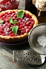 Tart with fresh raspberries, on wooden background