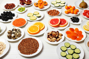 Different products on saucers on wooden table close up
