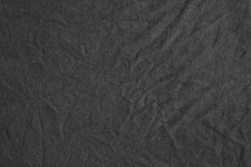 Black canvas with delicate striped pattern, crumpled.