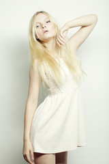  blond woman in white dress posing in studio